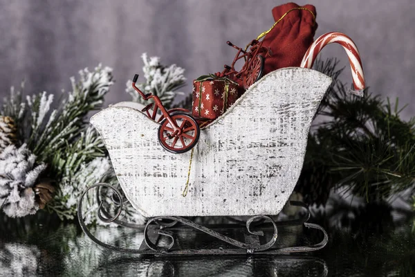 Миниатюрные Сани Наполненные Рождественскими Подарками Конфетами Отражающимися Влажном Зеркале Фоне Лицензионные Стоковые Фото