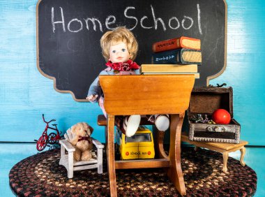 Oyuncak bebek dolu küçük bir masa ve evde oyuncaklarla çevrili bir yığın kitap.