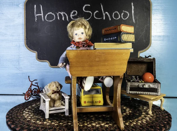 Oyuncak bebek dolu küçük bir masa ve evde oyuncaklarla çevrili bir yığın kitap.