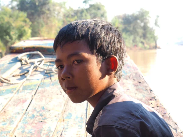 Arme jongen op de boot Stockfoto