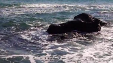 Deniz dalgaları taşa çarpar, fırtınalı deniz ve su üzerinde parlar. Karadeniz