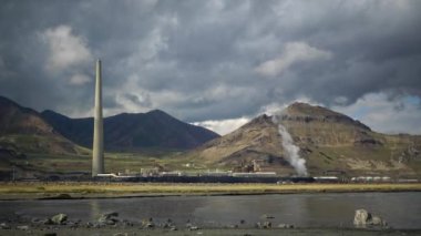 Petrol rafinerisi ve Büyük Tuz Gölü kıyısında dağların ve bulutların arka planına karşı gümüş elde etmek için bir fabrika. Utah, ABD