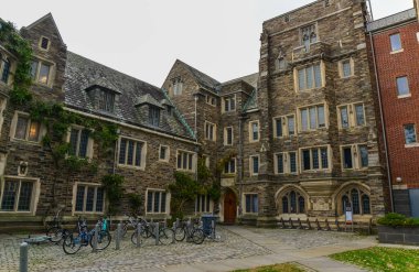 PRINCETON, NJ USA - 12 Kasım 2019: Princeton Üniversitesi 'nin eğitim binası yakınında bisiklet kullanan öğrenciler. Ivy League Kolej Binası, Princeton Üniversitesi, NJ USA