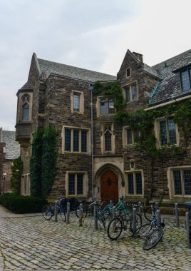 PRINCETON, NJ USA - 12 Kasım 2019: Princeton Üniversitesi 'nin eğitim binası yakınında bisiklet kullanan öğrenciler. Ivy League Kolej Binası, Princeton Üniversitesi, NJ USA