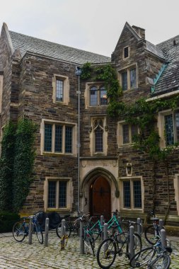 PRINCETON, NJ USA - 12 Kasım 2019: Princeton Üniversitesi 'nin eğitim binası yakınında bisiklet kullanan öğrenciler. Ivy League Kolej Binası, Princeton Üniversitesi, NJ USA