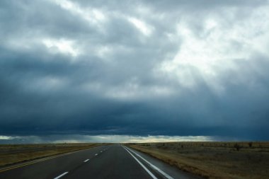 Gün batımında New Mexico, ABD 'de karayolu üzerinde gök gürültülü fırtına bulutları