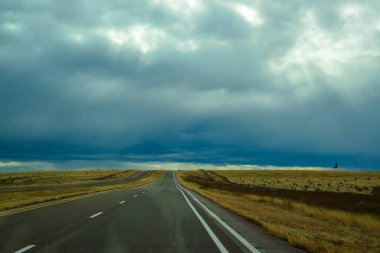 Gün batımında New Mexico, ABD 'de karayolu üzerinde gök gürültülü fırtına bulutları