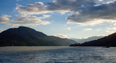Karda dağlar, odunla kaplanmış. Dağların üzerinde kalın bulutlar.