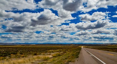 Rüzgâr türbinleri büyük beyaz bulutların arka planında, Utah, ABD 'deki araba penceresinden esiyor.