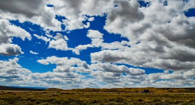 Rüzgâr türbinleri büyük beyaz bulutların arka planında, Utah, ABD 'deki araba penceresinden esiyor.