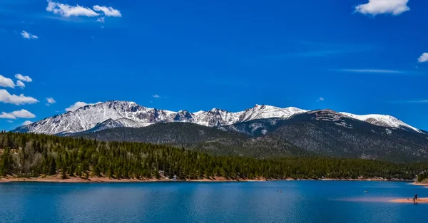 Pike Peak Panorama 'da. Colorado Baharı, Colorado, ABD 'deki Pikes Tepesi Dağları' nda bir dağ gölü yakınında karla kaplı ve ormanlı dağlar.