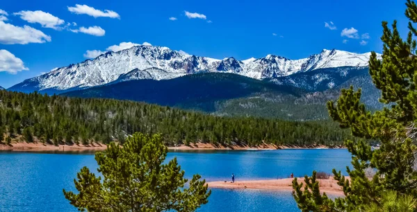 Pike Peak Panorama 'da. Colorado Baharı, Colorado, ABD 'deki Pikes Tepesi Dağları' nda bir dağ gölü yakınında karla kaplı ve ormanlı dağlar.