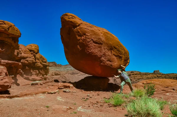 Balancing rock at the bottom of a canyon among Layered geological formations of red rocks. USA