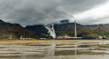 Petrol rafinerisi ve Büyük Tuz Gölü kıyısında dağların ve bulutların arka planına karşı gümüş elde etmek için bir fabrika. Utah, ABD