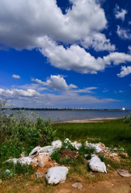 Doğanın kirliliği, bir rezervuarın kıyısındaki plastik çöp yığını, ekolojik felaket, Ukrayna.