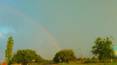 Lightning and rainbow in the rain, a car rides, Ukraine