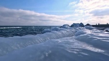 Karadeniz 'in kışın kıyılarında, Ukrayna' nın Odesa kentinde meydana gelen fırtınadan sonra donmuş deniz suyu ve kıyı kayaları üzerinde mavi buz oluşumları görülüyor.