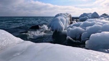 Karadeniz 'in kışın kıyılarında, Ukrayna' nın Odesa kentinde meydana gelen fırtınadan sonra donmuş deniz suyu ve kıyı kayaları üzerinde mavi buz oluşumları görülüyor.