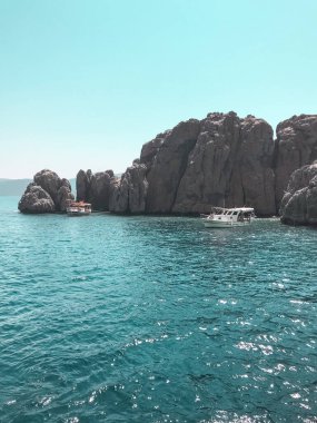 Taşlı gök mavisi deniz. Yaz tatili. Denizin ortasında kayıklar.