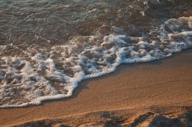Şafak güneşinin ışınlarında deniz köpüğü