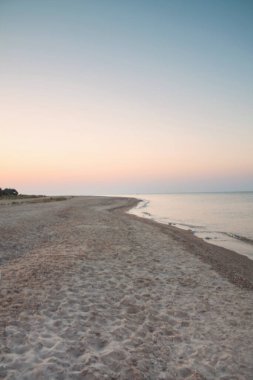 Gün doğumunda tükürüğün kenarındaki sahil.