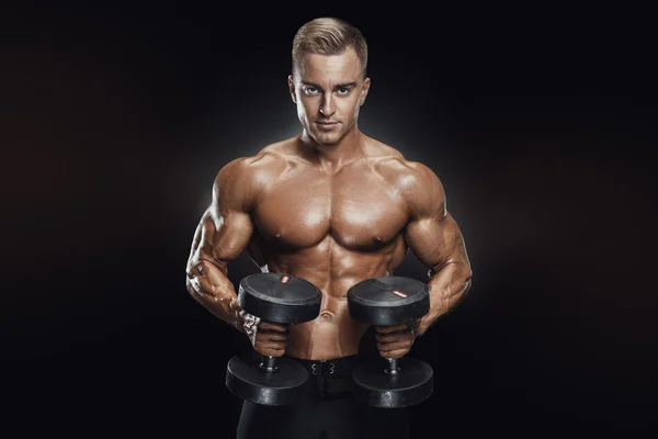 Knappe atletische kerel workout met dumbbells — Stockfoto