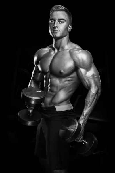 Handsome athletic guy workout with dumbbells — Stock Photo, Image