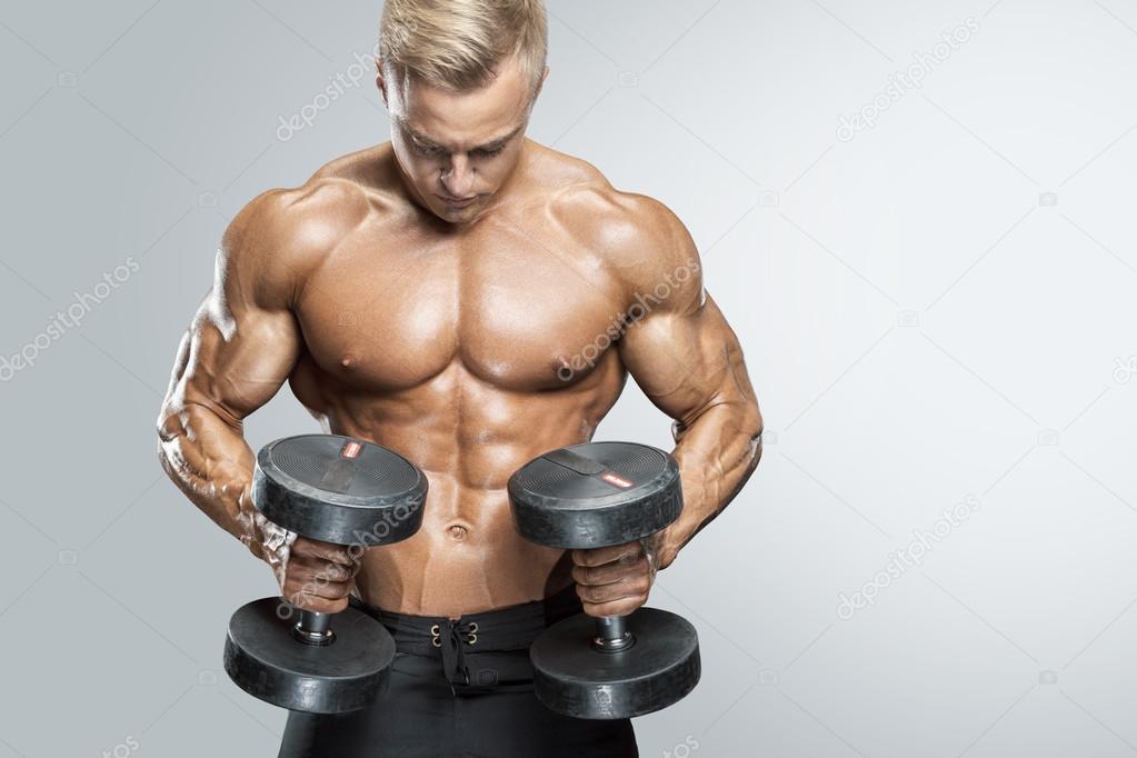 Handsome athletic guy workout with dumbbells Stock Photo by ©Improvisor  112137300