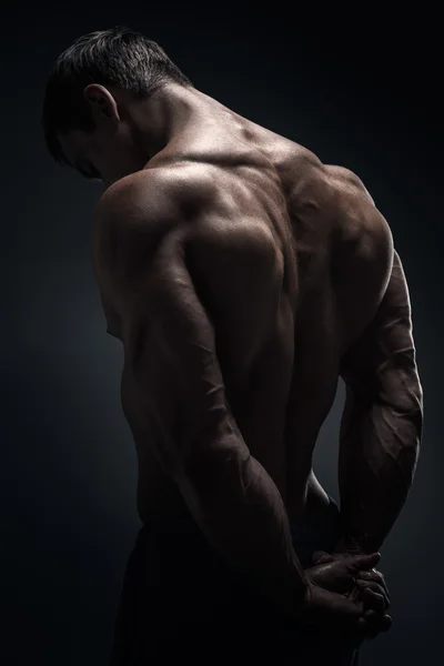 Handsome muscular bodybuilder posing over black background — Stock Photo, Image