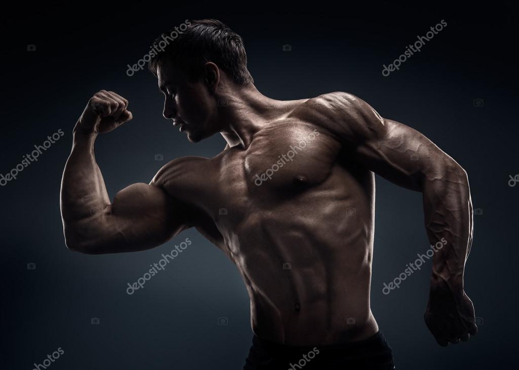 Handsome muscular bodybuilder posing over black background Stock Photo by  ©Improvisor 58642457