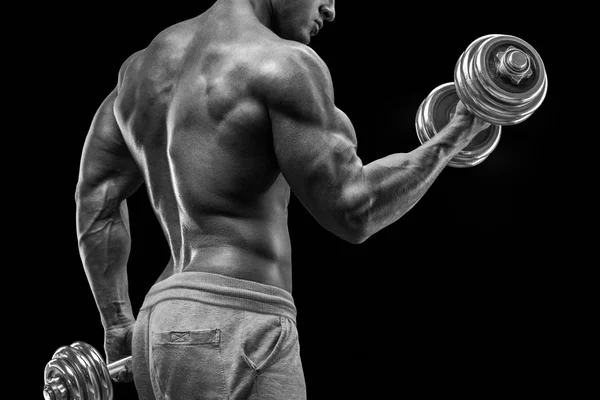 Poder atlético homem no treinamento bombeamento de músculos com halteres — Fotografia de Stock