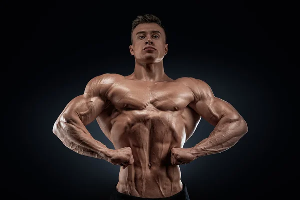 Schöner muskulöser Bodybuilder posiert auf vorderer Latzspreizung — Stockfoto