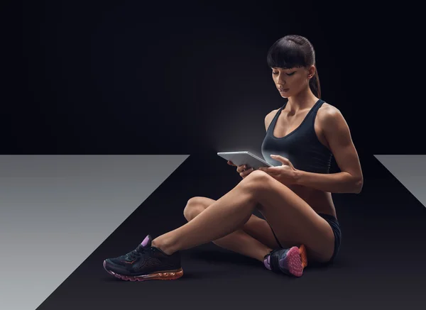 Fitness mujer deportiva usando una tableta digital —  Fotos de Stock