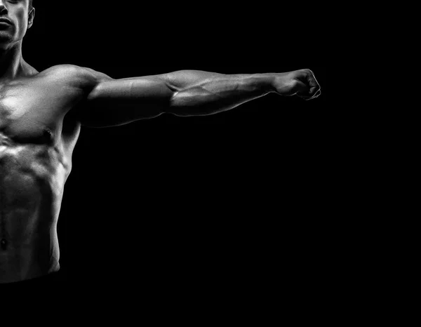 Bonito fisiculturista muscular posando e mantendo os braços estendidos — Fotografia de Stock