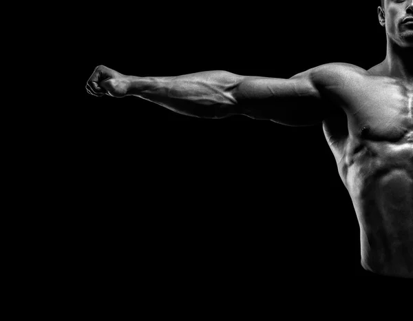 Bonito fisiculturista muscular posando e mantendo os braços estendidos — Fotografia de Stock