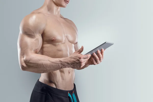 Sportief en fit jonge man met behulp van een digitale tablet — Stockfoto