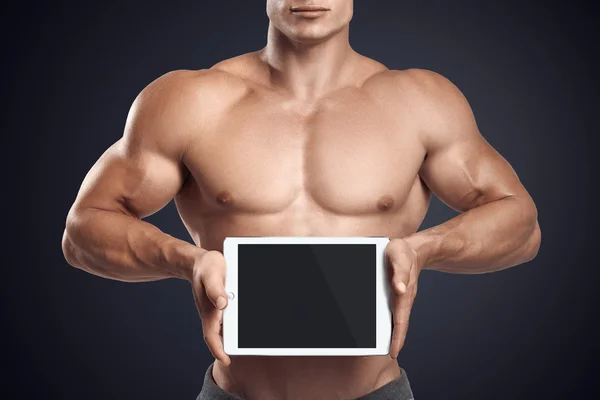 Fitness masculino sosteniendo horizontalmente tableta digital con scre en blanco —  Fotos de Stock