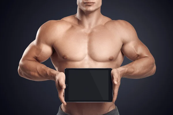 Fitness man houden horizontaal digitale tablet met lege scre — Stockfoto