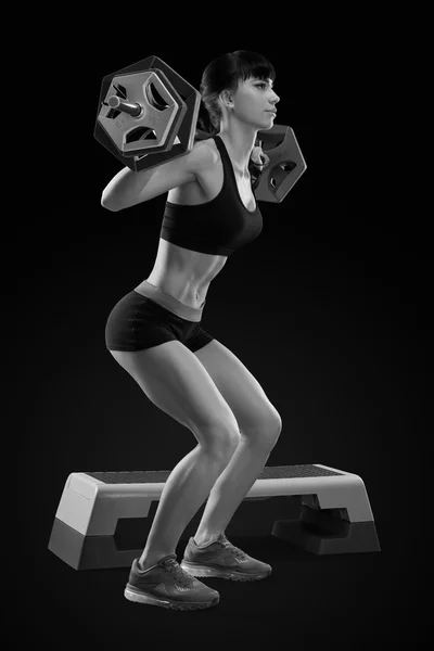 Vrouw fitnesstraining met barbell op sportschool — Stockfoto