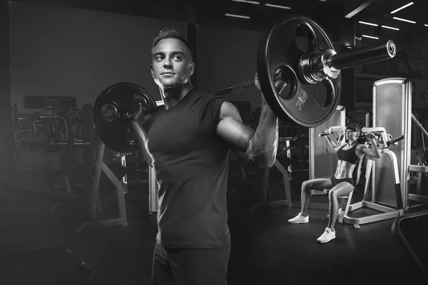 Pareja joven y en forma en el gimnasio haciendo ejercicio —  Fotos de Stock