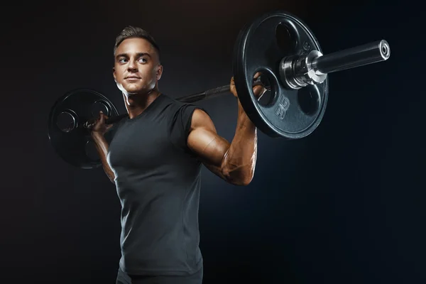 Muscular homem formação agachamentos com sinos sobre a cabeça — Fotografia de Stock