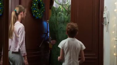 Çocuklar Kurye ile Noel Ağacı Tanışır. Bir kurye eve büyük ambalajlı bir Noel ağacı getirir. O, çocuklar tarafından karşılanır. Kız tabletin üzerine imza atıyor. Kurye çocuğa Noel ağacı süsü verir.