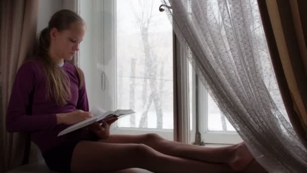 Χριστουγεννιάτικο Χιόνι Έξω Από Παράθυρο Μια Έφηβη Κάθεται Στο Περβάζι — Αρχείο Βίντεο