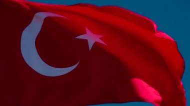 Türk Bayrağı Rüzgarı Kıpırdatıyor. Büyük Eyalet Bayrağı güneş tarafından aydınlatılır ve mavi gökyüzüne karşı destansı bir şekilde dalgalanır. Slow Motion 240 fps