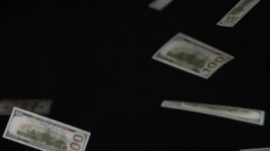 Sonsuz Kâr. Parasal değerler 100 dolar ve yavaşça siyah arkaplan üzerine düşüyor. 240 fps hızla çekiliyor.