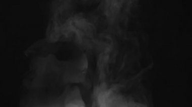 Yavaş Hareketli Buharlı Buhar. Beyaz Buhar perde arkasındaki büyük bir çömlekten yükseliyor. Siyah arka plan. 240 fps hızla çekiliyor.