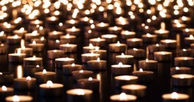 Candles of Memory. A large field of lit small candles on a dark granite surface. The air is slowly waving lights. Filmed at a speed of 120fps