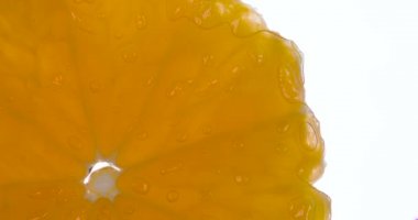 Mandarin Dilimleri Baskı Altında Patlar. Dilimler ve mandalina parçaları sıkıştırılır ve parlak beyaz bir arka planda ezilerek sulu bir hamuru ve kabuğu oluşturur. 120fps 'te atış