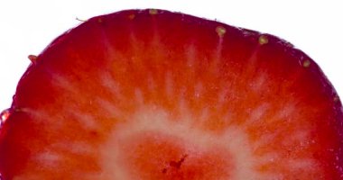 Çilek kokulu yarısını sık. Halves ve Whole Strawberries sıkıştırılır ve parlak beyaz bir arka planda ezilir, sulu bir hamur ve meyve suyu serpintisi oluşturur. 120 fps 'te atış.