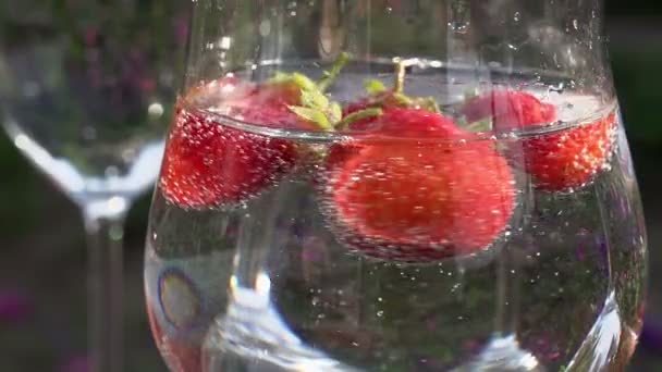 Erdbeere dreht sich im Glas mit Wasser. — Stockvideo